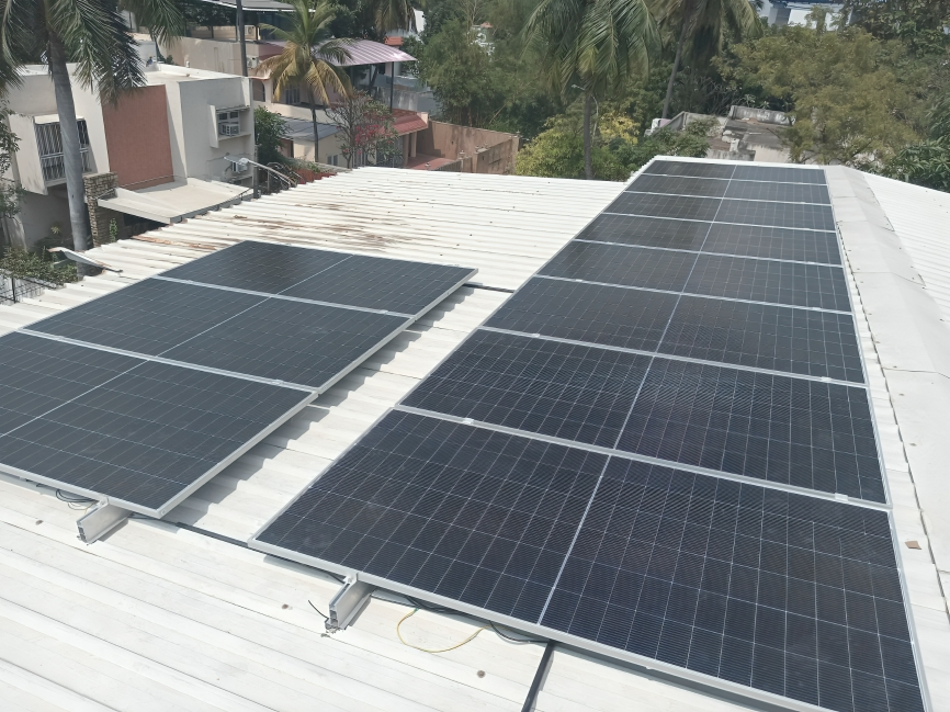 Solar panel installation on a white corrugated metal roof at Dr. (Col.) M A S Warrier's Residence in Defence Colony, Chennai