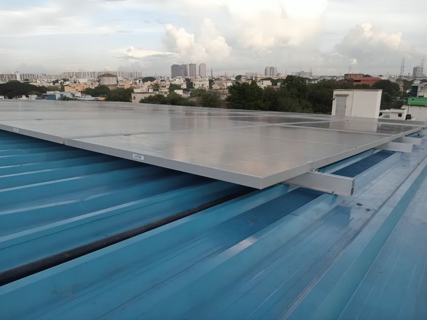 Professional solar panel installation on blue corrugated metal roof with urban cityscape background